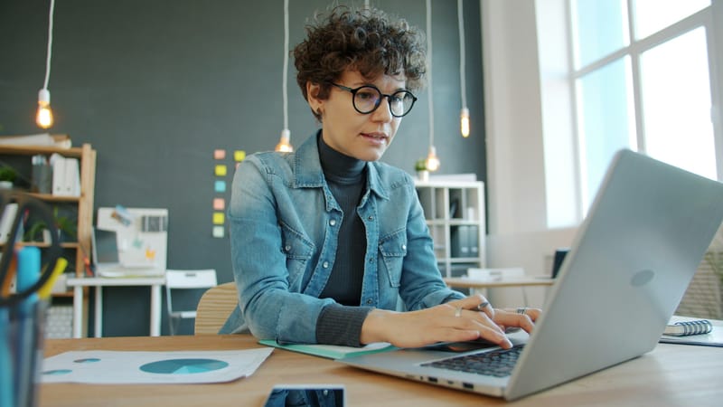 Transaction coordinator focused at her laptop in a bright modern office